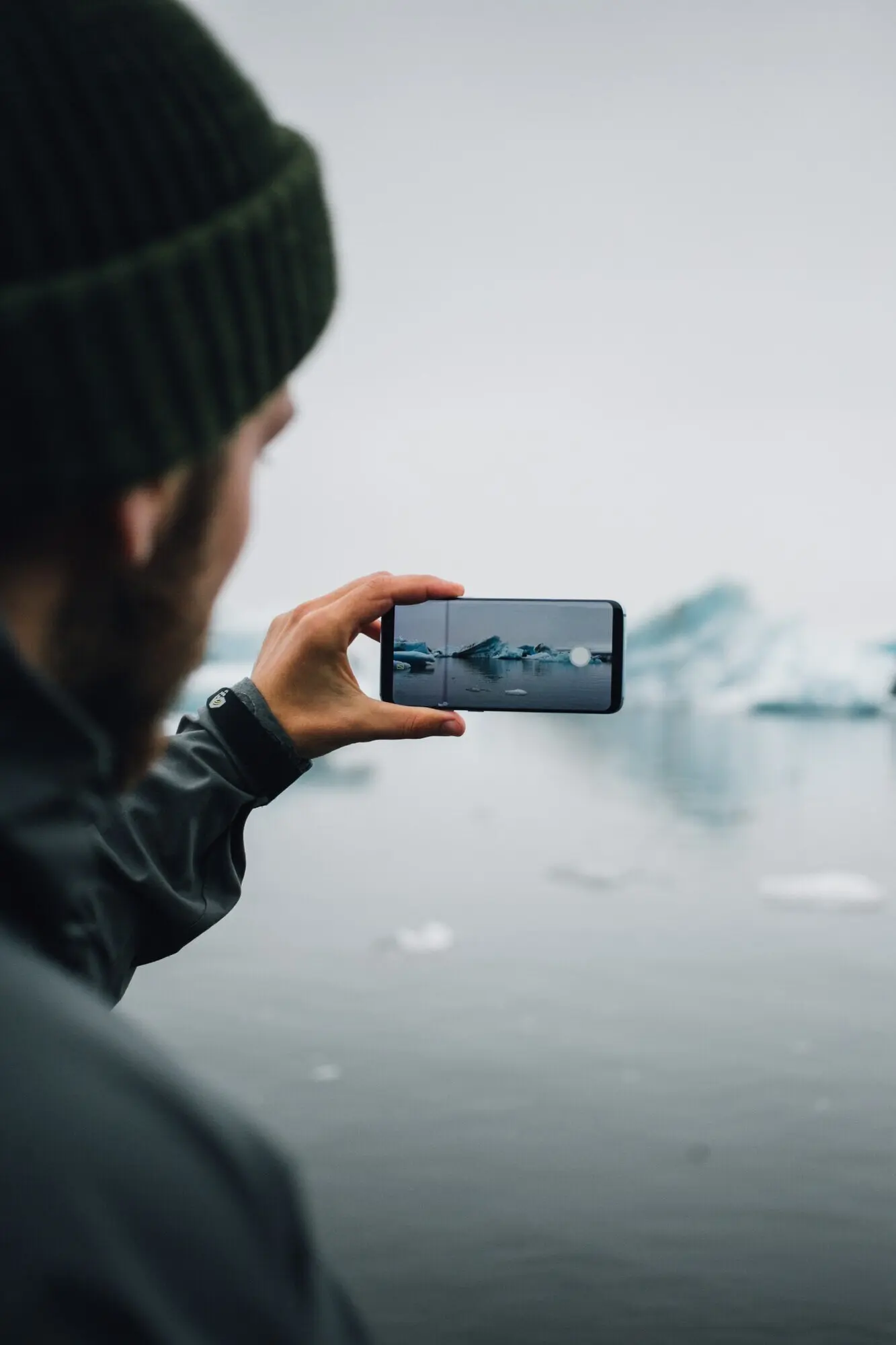 Ein Tourist beobachtet einen Gletscher im Wasser in Island.